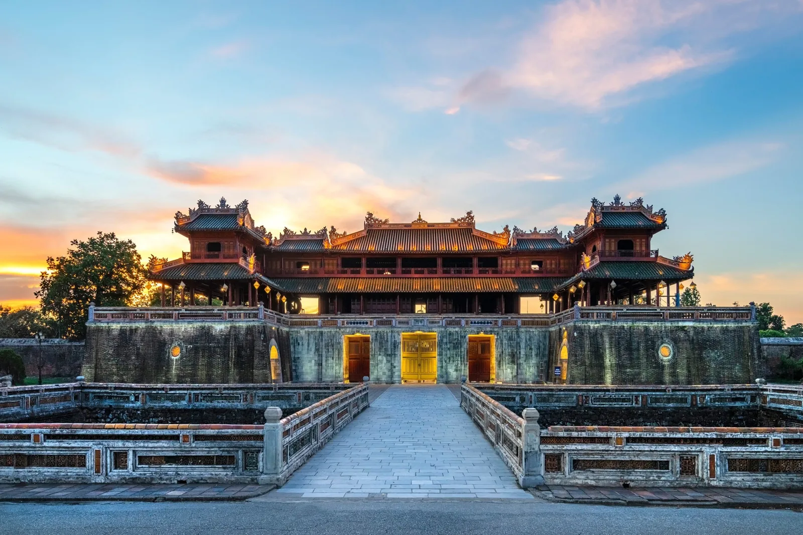 Ngọ Môn của Kinh thành Huế rực sáng lúc hoàng hôn phía sau cầu đá và hào nước.