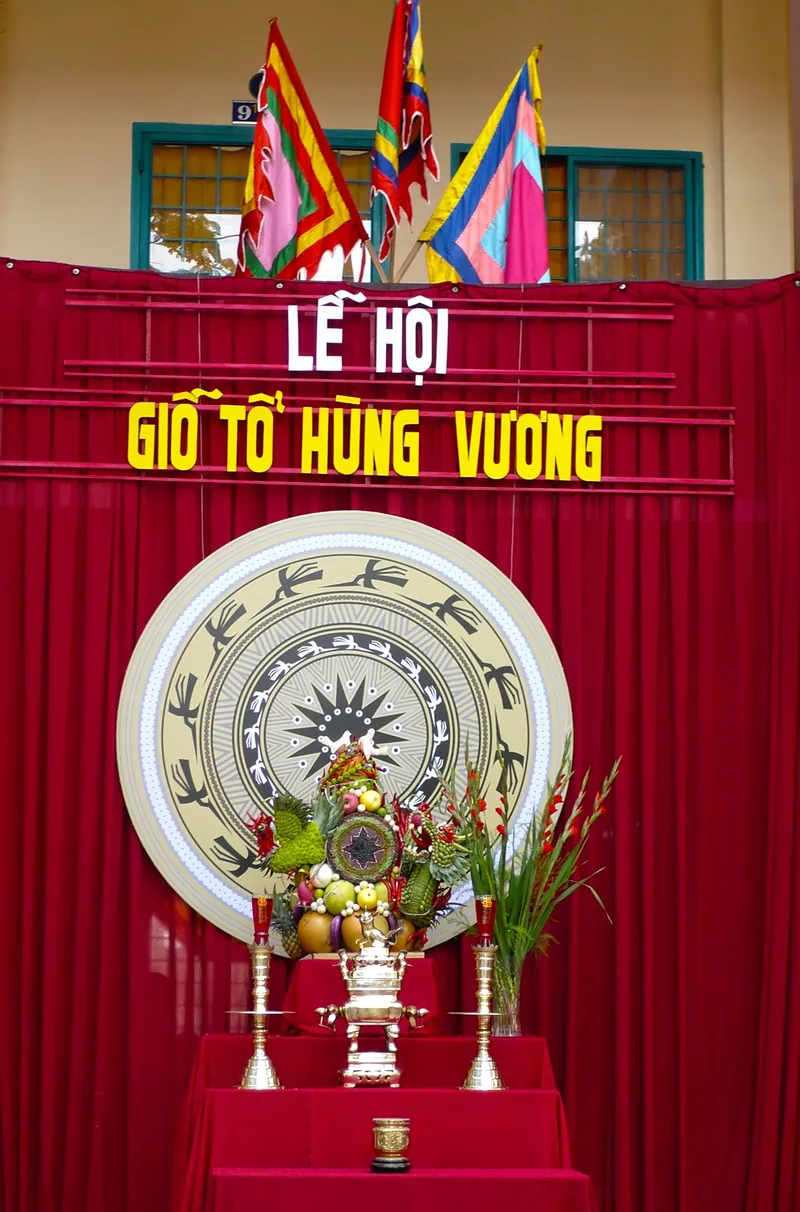 Bàn thờ với lễ vật hoa quả và trống đồng đặt trước rèm đỏ trong lễ hội Giỗ Tổ Hùng Vương ở Phú Thọ.