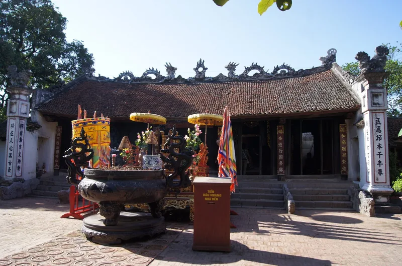 Đỉnh đồng lớn cùng những chiếc lọng vàng đặt trước tiền đường mái ngói của đền Trần ở Nam Định.