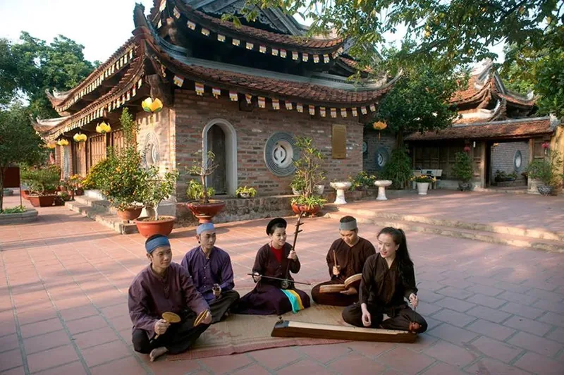 Nhóm nghệ nhân hát xẩm ngồi trên chiếu trong sân đền ở Nam Định.
