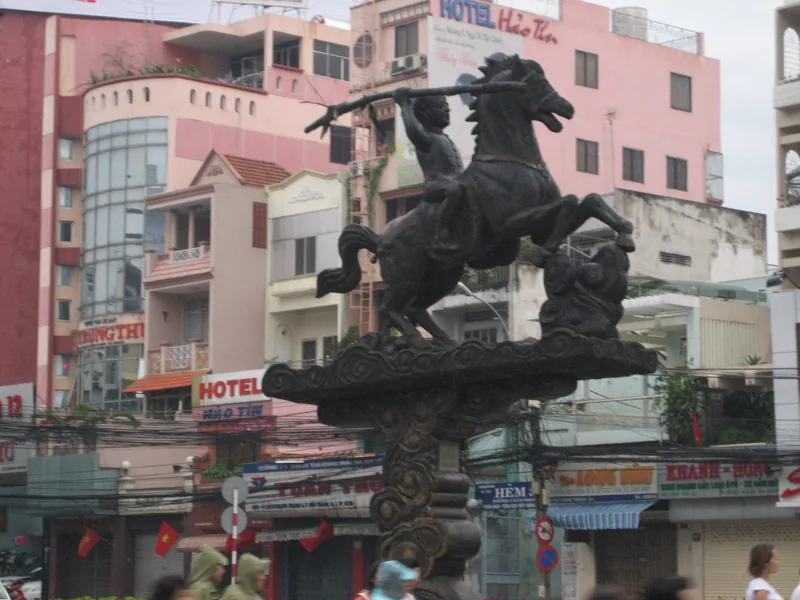 Tượng đồng Thánh Gióng cưỡi ngựa nổi bật trên bùng binh giữa những ngôi nhà phố nhiều màu sắc ở Hà Nội.