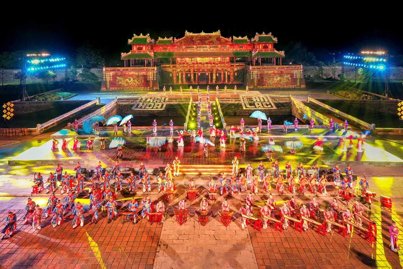 Buổi trình diễn nghệ thuật với trống hội và vũ công trong trang phục sặc sỡ diễn ra trước hoàng cung Huế lộng lẫy ánh đèn.