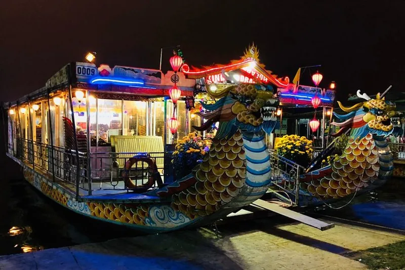 Thuyền rồng rực rỡ đèn lồng và đèn neon vào ban đêm trên sông Hương ở Huế.