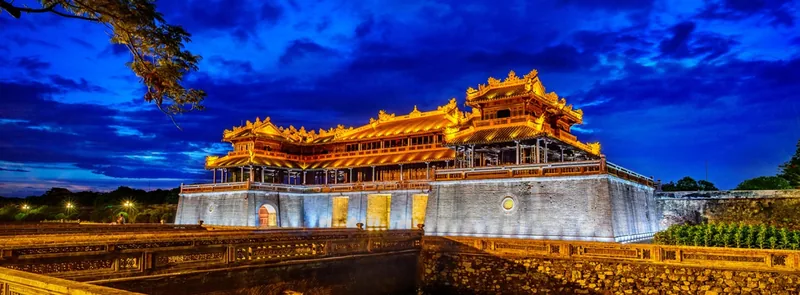 Cổng Ngọ Môn của Kinh thành Huế rực sáng ánh vàng trên nền trời chiều tím xanh huyền ảo.