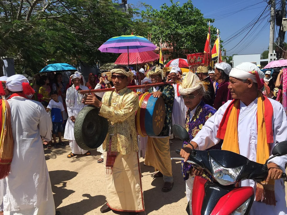 Người Chăm mặc trang phục truyền thống khiêng cồng và trống trong đoàn diễu hành lễ hội Katê ở Ninh Thuận.