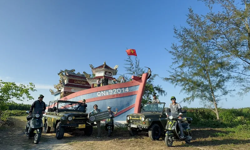 Đoàn xe jeep dừng chân bên lăng cá Ông trang trí công phu ở vùng nông thôn Hội An dưới trời xanh.