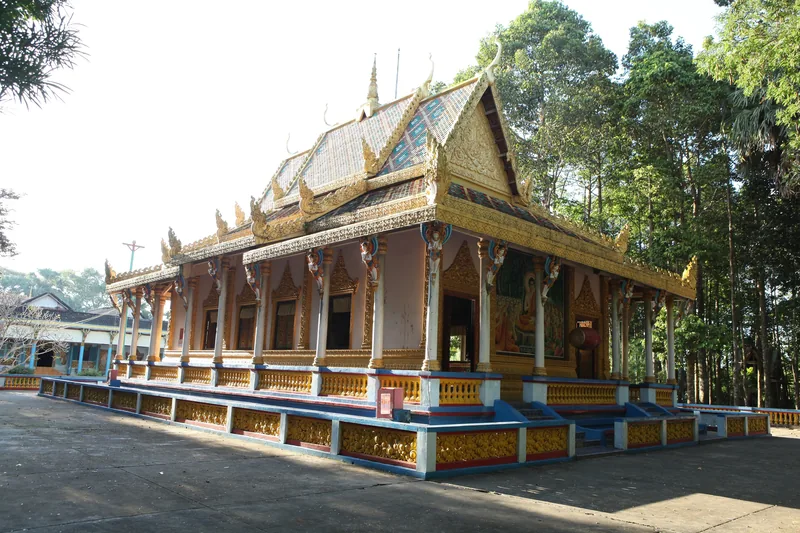 Ngôi chùa Khmer với mái ngói dát vàng nhiều tầng nổi bật bên hàng cây cao ở Sóc Trăng.